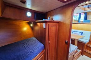 Cozy cabin interior of 2005 Stevens 1200 Vlet with wooden furnishings and porthole.
