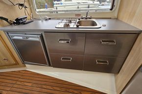 Compact kitchen area in 2023 Balt 818 Titanium boat with sink, stove, and fridge.