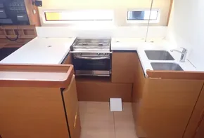 Modern kitchen in 2019 Jeanneau Sun Odyssey 440 yacht with stove and dual sinks.