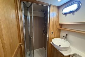Modern bathroom in 2024 Piper 12c with shower, sink, and wooden accents.