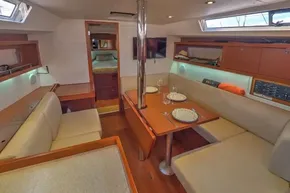 Luxurious interior of 2013 Beneteau Oceanis 41 sailboat with dining area and cozy seating.