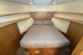 Cozy bedroom in 2024 Piper 12c boat with wooden cabinetry and soft lighting.