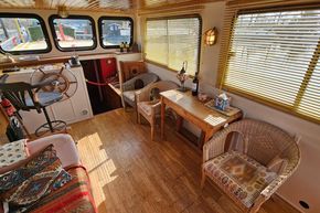 Interior of a 1927 Classic Dutch Barge with cozy seating and nautical decor.