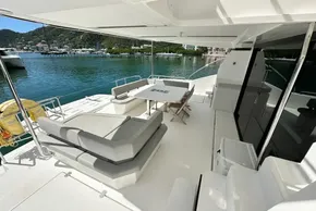 Leopard 53 Powercat 2022 yacht deck with seating, table, and scenic marina view.