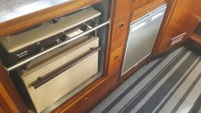 1982 Fairline Mirage 29 Aft Cabin kitchen with stove and fridge, featuring wood cabinetry.