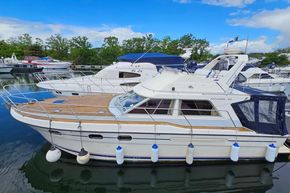 1989 Princess 35 Flybridge yacht docked at marina, featuring sleek design and wooden deck.