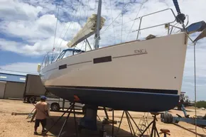 2013 Beneteau Oceanis 41 sailboat on dry dock under a partly cloudy sky.