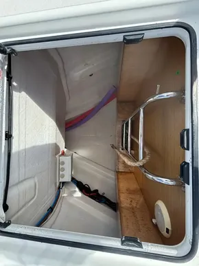 Storage compartment of a 2019 Jeanneau Sun Odyssey 440 sailboat, featuring wiring and a metal handle.