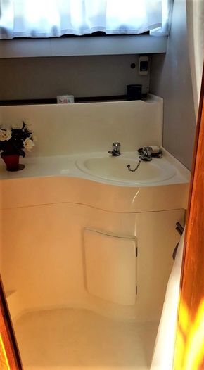 Compact bathroom in 1995 Aquafibre Bounty Boats 10/70, featuring sink and floral decor.