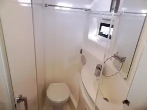 Compact bathroom in 2015 Leopard 51 Powercat with toilet, sink, and window.