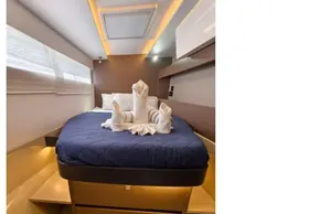 Luxurious cabin interior of 2021 Leopard 50 yacht with elegant bedding and ambient lighting.