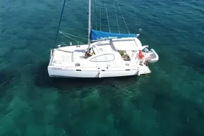 Aerial view of 2008 Leopard 38 catamaran sailing on clear turquoise waters.