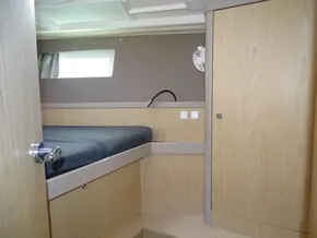 Interior cabin of 2017 Beneteau Oceanis 45 yacht with wooden finish and bed.