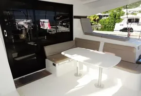 Lagoon 42 2020 yacht with outdoor seating area and table, docked at marina.