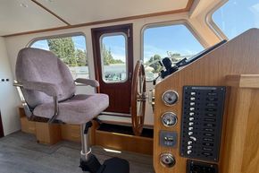 Pilot seat and control panel inside a 2024 Piper 12c boat cabin.