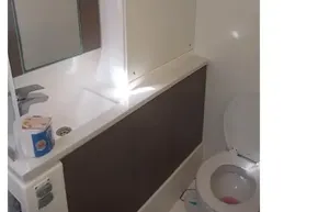 Modern bathroom in 2022 Leopard 45 yacht with sink, mirror, and toilet.