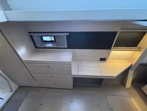 Modern interior of 2019 Leopard 40 catamaran with sleek wood finish and compact storage.