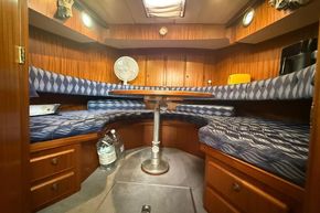 Cozy cabin interior of 1994 Linssen 360 AC yacht with wooden furnishings and cushioned seating.