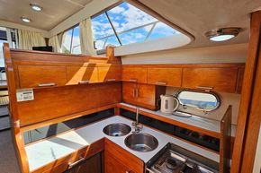 Interior of 1989 Princess 35 Flybridge yacht kitchen with wood cabinetry and modern appliances.