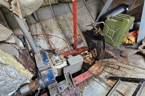 Engine room of a 1927 Classic Dutch Barge with visible machinery and fuel can.