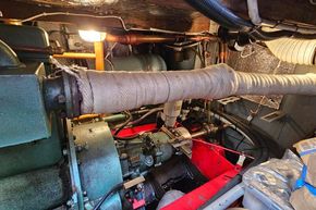 Engine room of a 1921 Classic Dutch Barge, showcasing vintage machinery and piping.