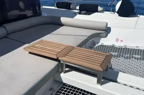 Luxurious 2024 Lagoon 42 catamaran deck with cushioned seating and wooden table.