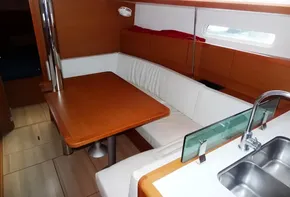 Interior of 2017 Jeanneau Sun Odyssey 389 sailboat with dining area and kitchenette.