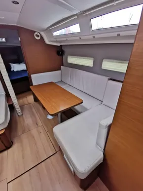 Interior of 2020 Jeanneau Sun Odyssey 410 with cozy seating and wooden table.