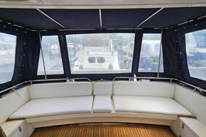 Interior view of 1989 Princess 35 Flybridge yacht with cushioned seating and enclosed canopy.