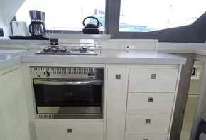Modern kitchen in 2017 Leopard 45 yacht with stove, oven, and storage drawers.