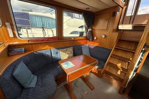 Cozy interior of a 1994 Linssen 360 AC yacht with wooden furnishings and seating area.