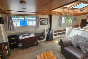 Interior of a 1926 Dutch Barge Luxemotor with cozy seating and wood stove.