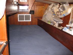 The Captain's cabin includes a queen bed, a hanging locker, cabinets & large lockers beneath.