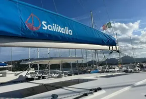 Leopard 45 catamaran with Sailitalia branding, docked in a sunny marina.