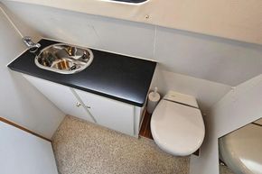 Bathroom interior of 1921 Classic Dutch Barge with sink and toilet.