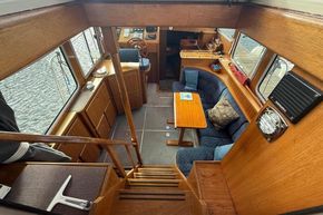 Interior of 1994 Linssen 360 AC yacht with wooden furnishings and cozy seating area.