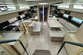 Luxurious interior of 2023 Beneteau Oceanis 51.1 yacht with modern kitchen and seating area.