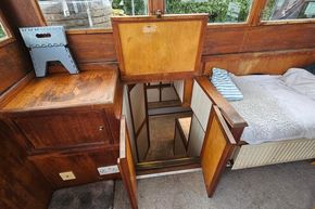 Interior of a 1926 Dutch Barge Luxemotor with wooden cabinetry and open hatch.