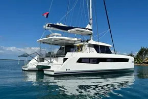 2022 Leopard 42 catamaran sailing on calm blue waters under a clear sky.