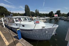 2024 Piper 12c boat for sale, docked at marina with flags and clear sky.
