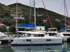 2020 Lagoon 42 catamaran docked in a scenic marina with hillside houses.