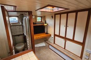 Luxemotor Dutch Barge 1926 interior with bathroom, wooden cabinets, and cozy workspace.