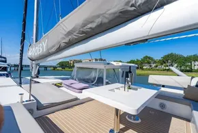 Luxurious 2022 Leopard 50 yacht deck with seating and table, docked by scenic waterfront.