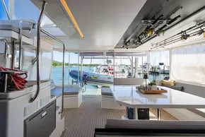 Luxurious 2022 Leopard 50 yacht interior with fishing rods, spacious seating, and marina view.