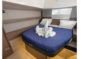 Luxurious cabin interior of 2021 Leopard 50 yacht with blue bedding and towel art.