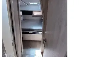 Interior cabin view of 2018 Leopard 45 catamaran, featuring a cozy bed and modern design.