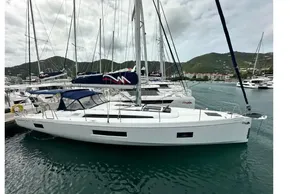 2023 Beneteau Oceanis 51.1 sailboat docked in a marina with scenic mountain backdrop.