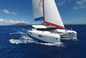 2020 Lagoon 42 catamaran sailing on open blue ocean.