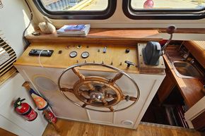 1927 Classic Dutch Barge helm with wooden wheel, gauges, and controls.
