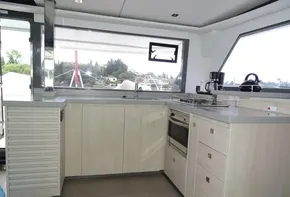 Modern kitchen interior on 2017 Leopard 45 yacht, featuring light wood cabinetry and appliances.